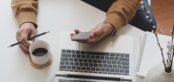 person-holding-white-coffee-cup-and-smartphone-3787321